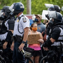 Cops and one small woman holding a BLM sign