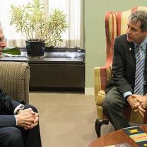 Merrick Garland and Sherrod Brown sitting in chairs looking at each other
