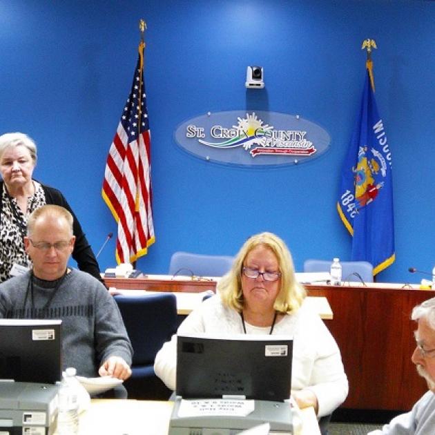 People doing a recount at tables with flags in the background